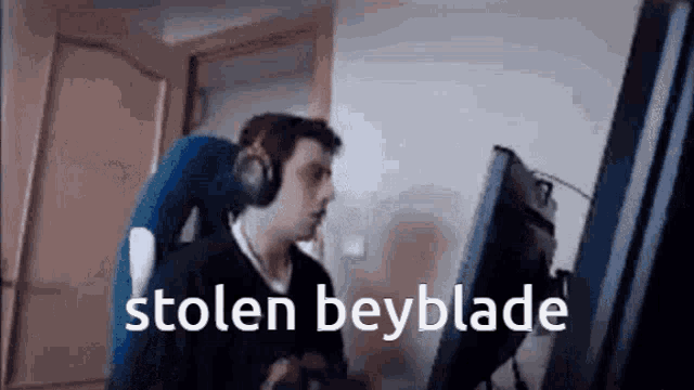 a man wearing headphones is playing a video game on a computer and says `` stolen beyblade '' .