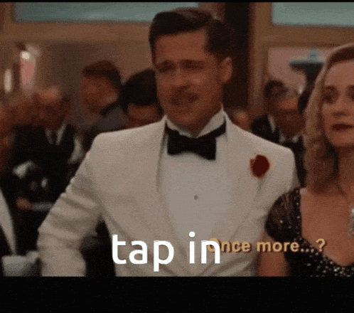 a man in a tuxedo is standing next to a woman and says tap in once more
