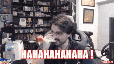 a man covering his nose in front of a sign that says ' hahaha '