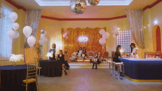 a room with balloons and a neon sign that says ' a '