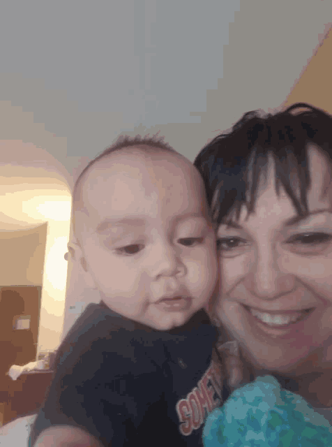a woman is holding a baby wearing a shirt that says ' comet '