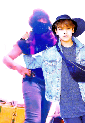 a boy in a denim jacket stands next to another boy