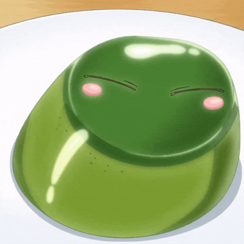 a green frog with a pink nose and eyes is on a white plate