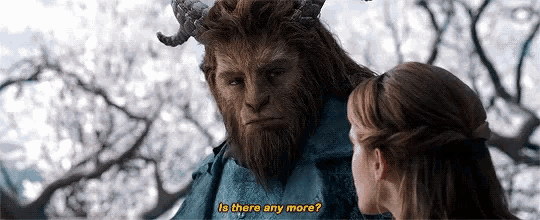 a woman is standing next to a beast with horns and a beard .