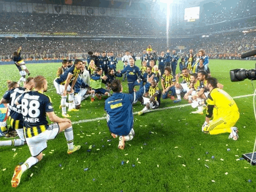 a group of soccer players kneeling on the field with one wearing the number 1438