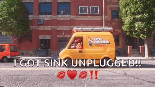 a yellow super mario bros plumbing van is driving down a street