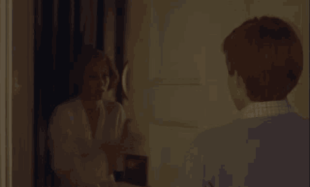 a man and a woman are looking at each other in a mirror