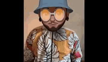a man with a beard and glasses is wearing a bucket hat and a hawaiian shirt .