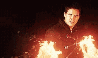 a man in a black jacket is holding a torch in his hands .