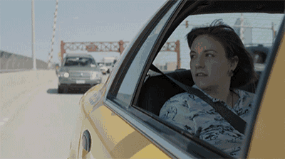 a woman is sitting in a taxi with a sign in the background that says container
