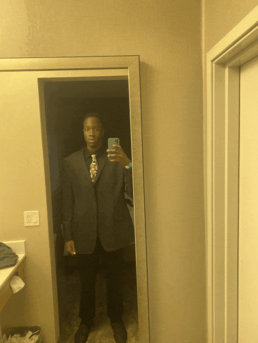 a man in a suit and tie is taking a selfie in the mirror