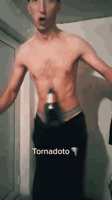 a man without a shirt is holding a bottle of tornadoto on his waist