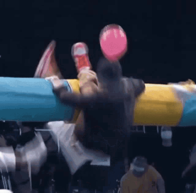 a person is holding a pink balloon in their hand while riding a roller coaster