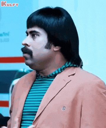 a man with a mustache and a wig is wearing a suit and a striped shirt .
