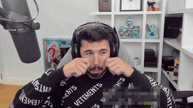 a man wearing headphones with the word vetements on his sweater
