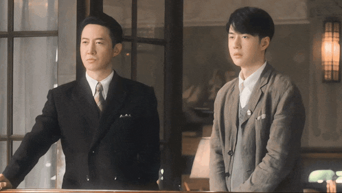 two men in suits standing next to each other
