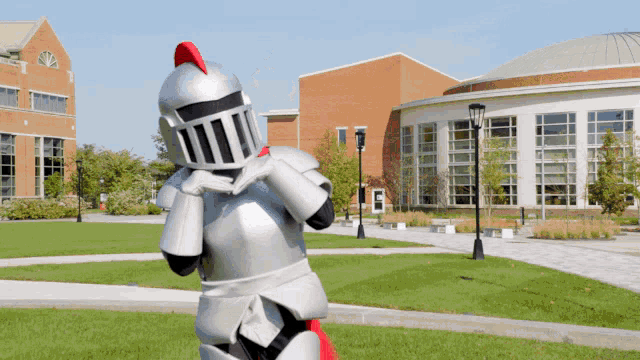 a knight mascot is standing in front of a building with a sign that says ' ucsd ' on it