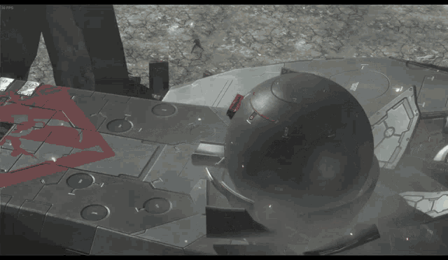 a large black object with a red arrow on it is sitting on a concrete surface