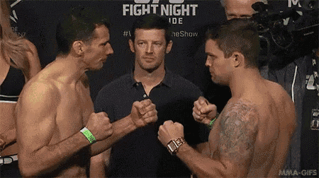 two men are standing next to each other in front of a sign that says fight night on it .