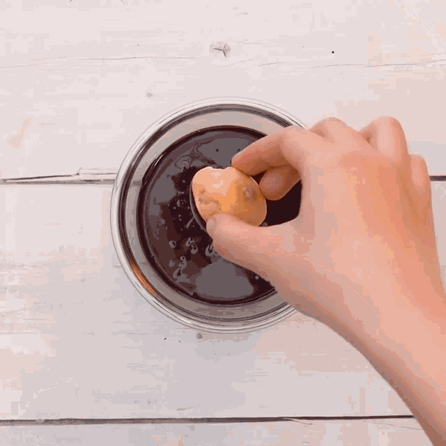 a cake being decorated with chocolate frosting on a wooden plate