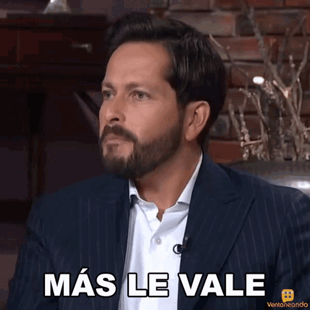 a man with a beard wearing a suit says mas le vale