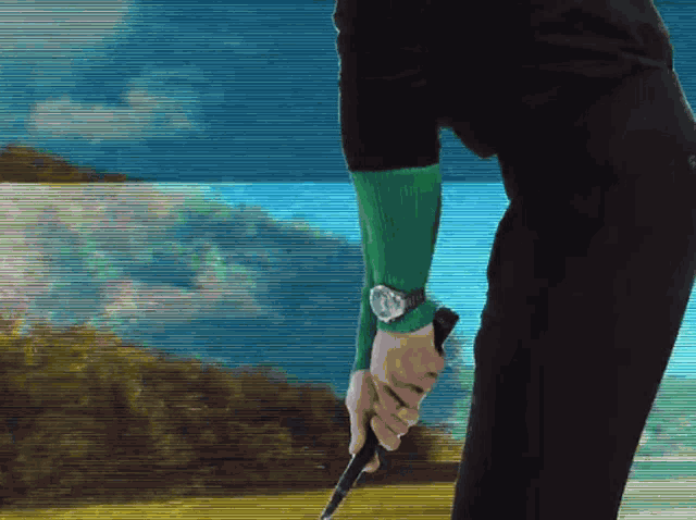 a man wearing a watch is swinging a golf club on a golf course