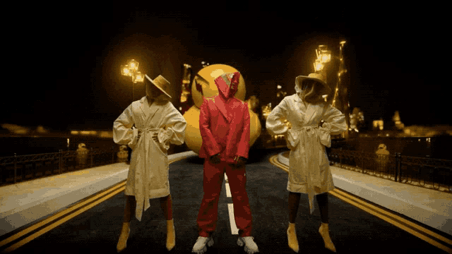 a man in a red suit is surrounded by two women in bathrobes