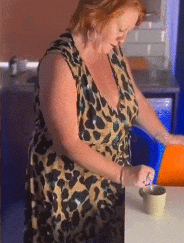 a woman in a leopard print dress is stirring a cup of coffee .