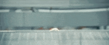 a close up of a man 's face peeking out from behind a fence