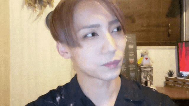 a close up of a person 's face with a stuffed animal behind them