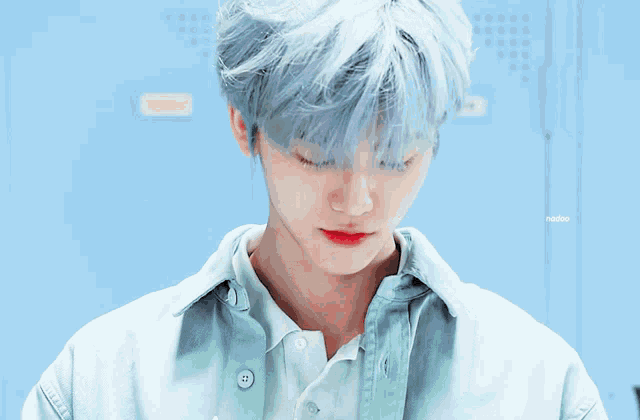 a boy with blue hair is smiling in front of a locker that says sunday