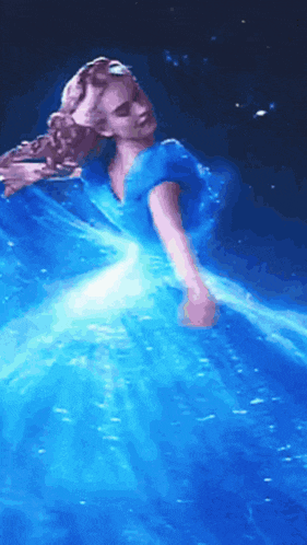 a woman in a blue dress is dancing on a stage .