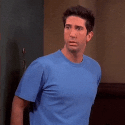 a man in a blue t-shirt stands in front of a door