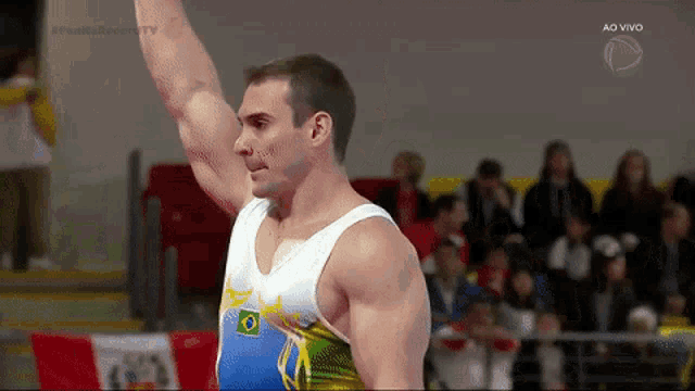 a man is lifting his arm in the air while a crowd watches .