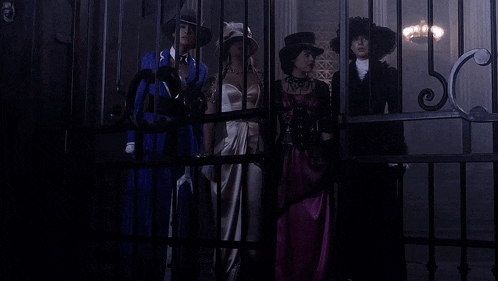 a group of women are standing behind a fence