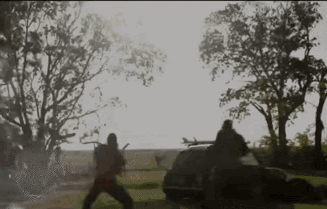 a blurry picture of a group of people standing around a car