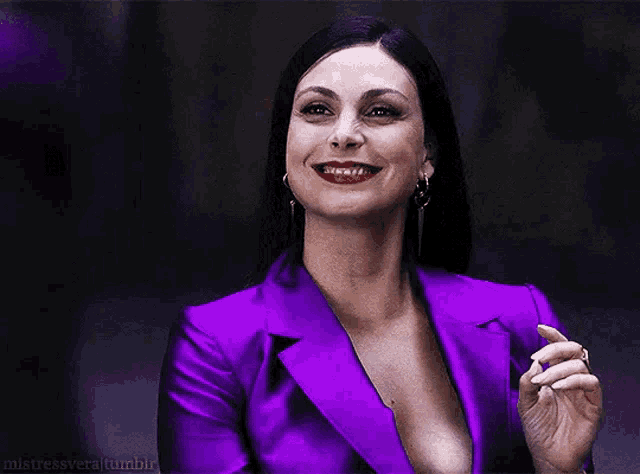 a woman in a purple jacket is smiling and smoking