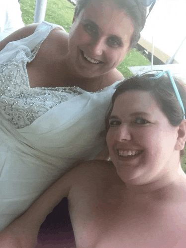 two women are posing for a picture and one is wearing a white dress