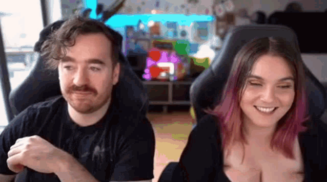 a man and a woman are sitting next to each other in a room .