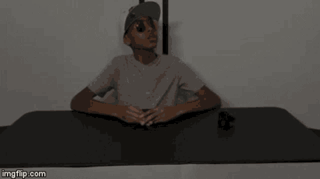 a boy wearing sunglasses and a hat sits at a table with imgflip.com at the bottom