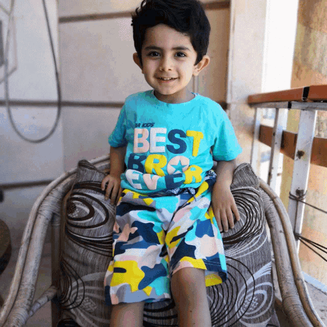 a young boy wearing a blue shirt that says best ever