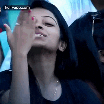 a woman is making a funny face while sitting in a crowd .