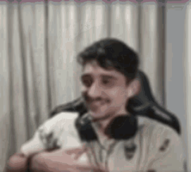 a blurry picture of a man wearing headphones and a white shirt .