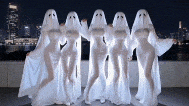 a group of women dressed as ghosts are standing in a line