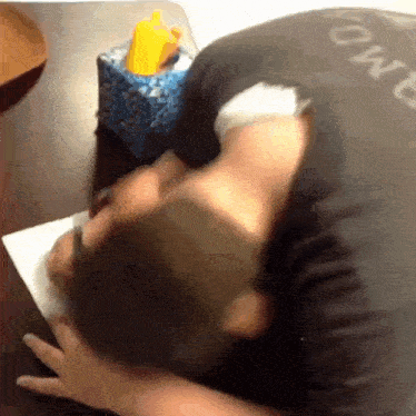 a man laying on a table with his head on a piece of paper with a box of tissues in the background