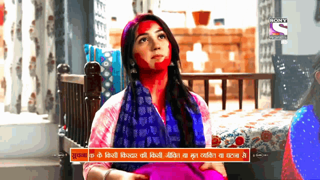 a woman with red paint on her face is on a sony channel