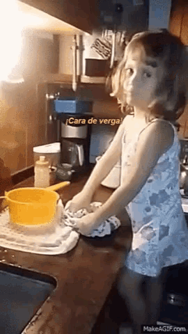 a little girl is washing dishes in a kitchen with a caption that says cara de verga .