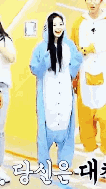 a woman in a blue and white animal costume is standing next to a man in a yellow costume .
