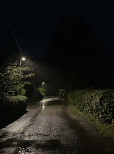 a dark street with a few lights on