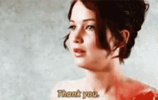 a woman is standing in front of a wall and saying thank you .